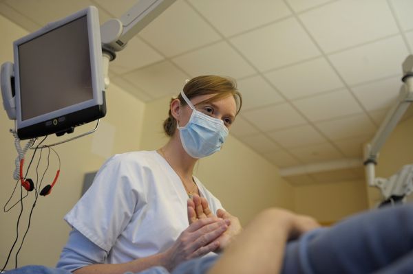 Infirmière au lit d’un patient équipée d’un masque
